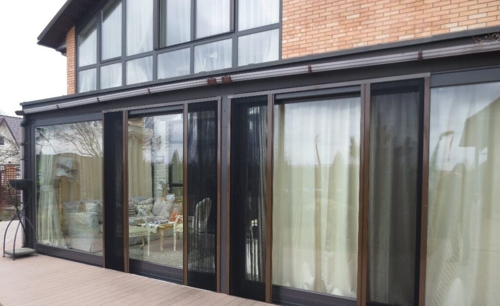 Встановлена розсувна москітна сітка на панорамних розсувних дверях заміської тераси